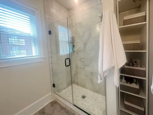 a bathroom with a shower and a window