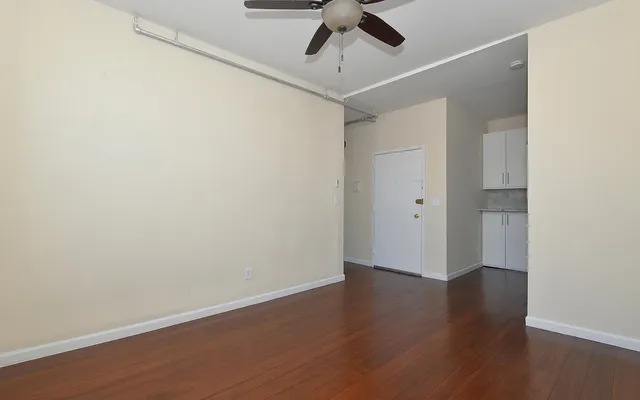 a view of an empty room with wooden floor