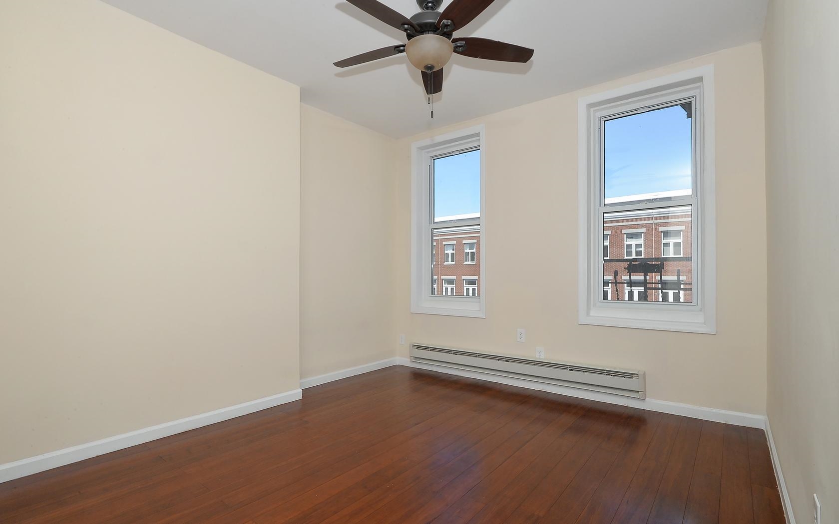 235 Monroe Street, Unit 9 Hoboken, NJ 07030 - Photo 15 of 15 an empty room with windows and ceiling fan