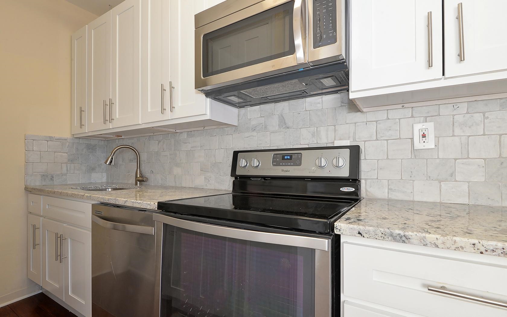 235 Monroe Street, Unit 9 Hoboken, NJ 07030 - Photo 2 of 15 a kitchen with stainless steel appliances granite countertop white cabinets and a stove top oven