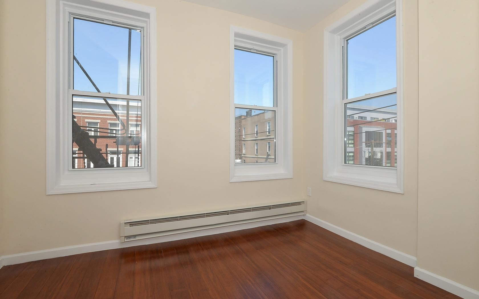 235 Monroe Street, Unit 9 Hoboken, NJ 07030 - Photo 3 of 15 a view of an empty room with wooden floor and a window