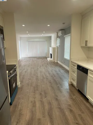 a view of empty room with a fireplace and wooden floor