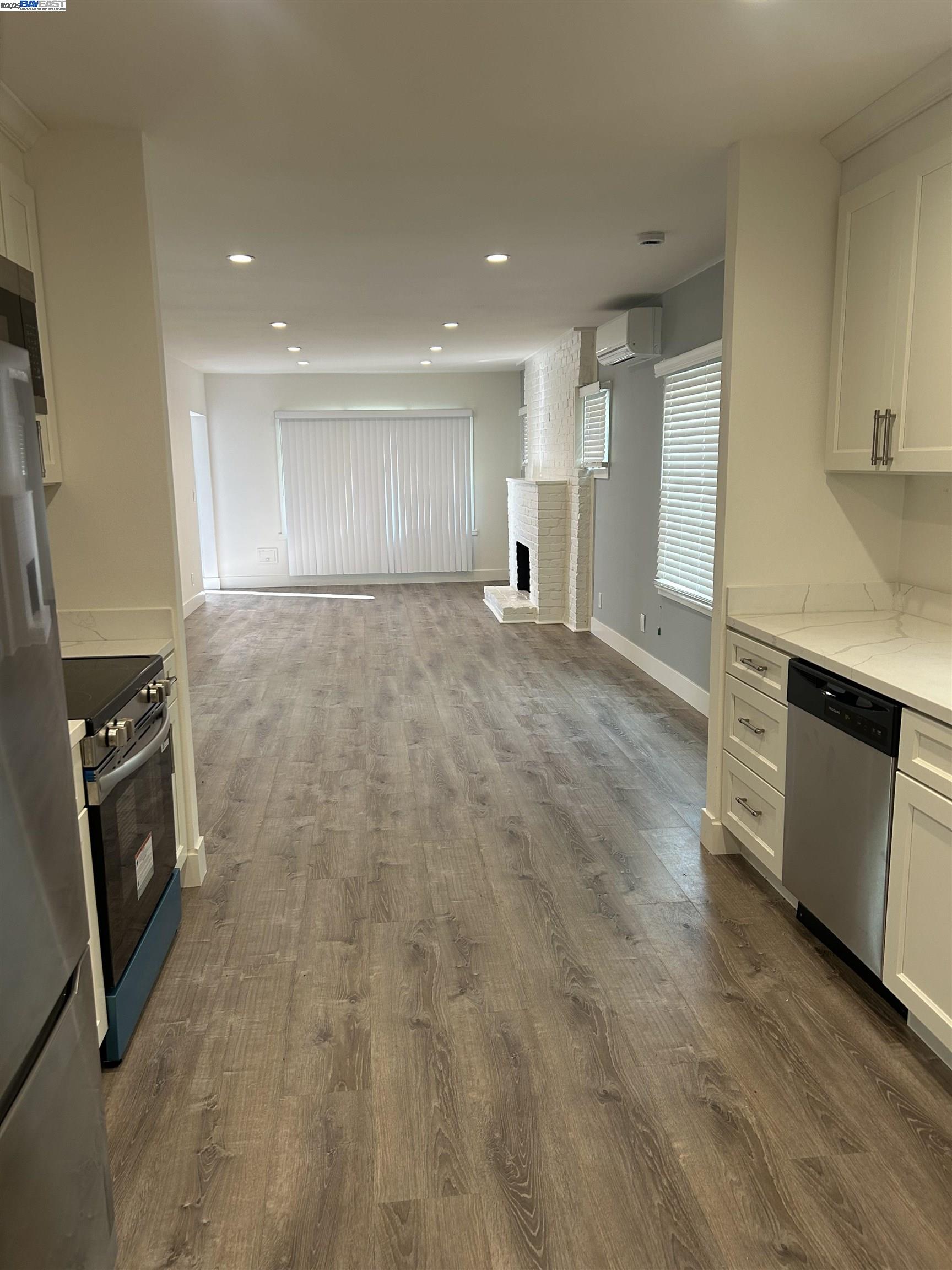 7808 Weld Street Oakland, CA 94621 - Photo 2 of 8 a view of empty room with a fireplace and wooden floor