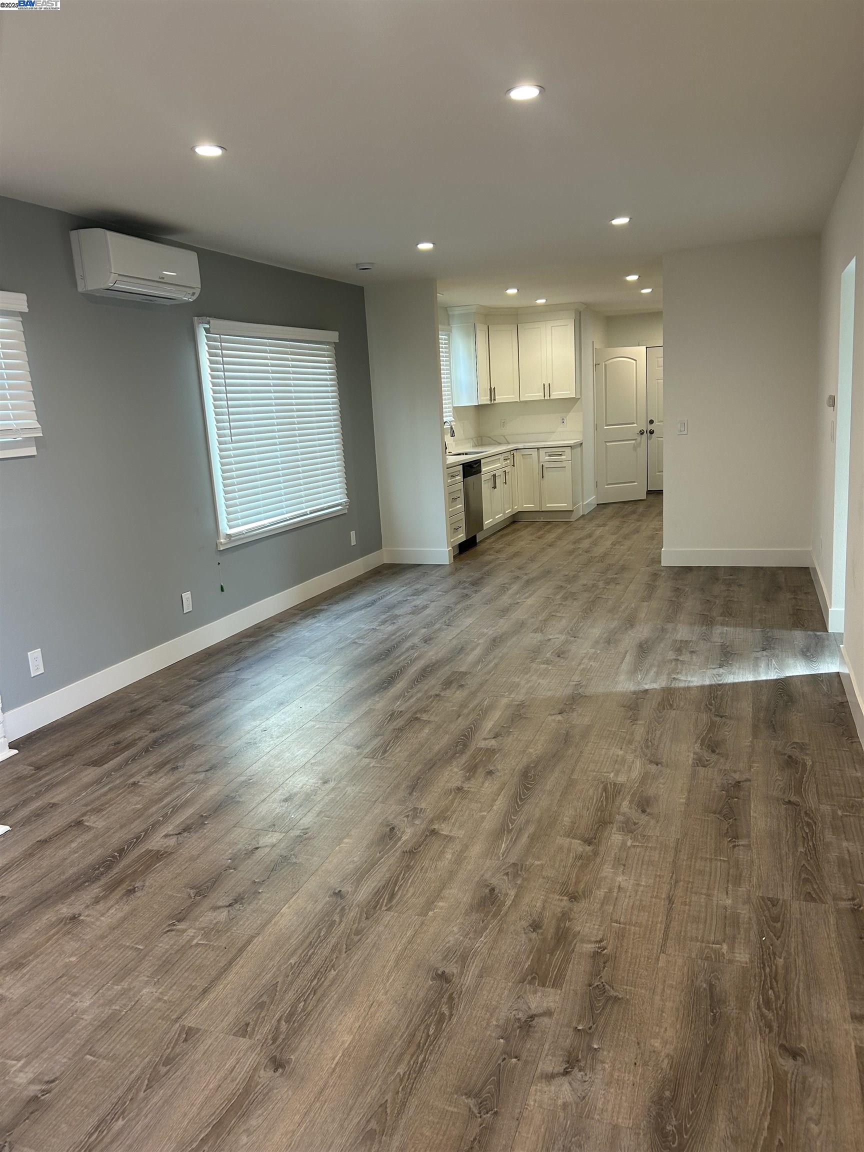 7808 Weld Street Oakland, CA 94621 - Photo 4 of 8 an empty room with wooden floor and windows