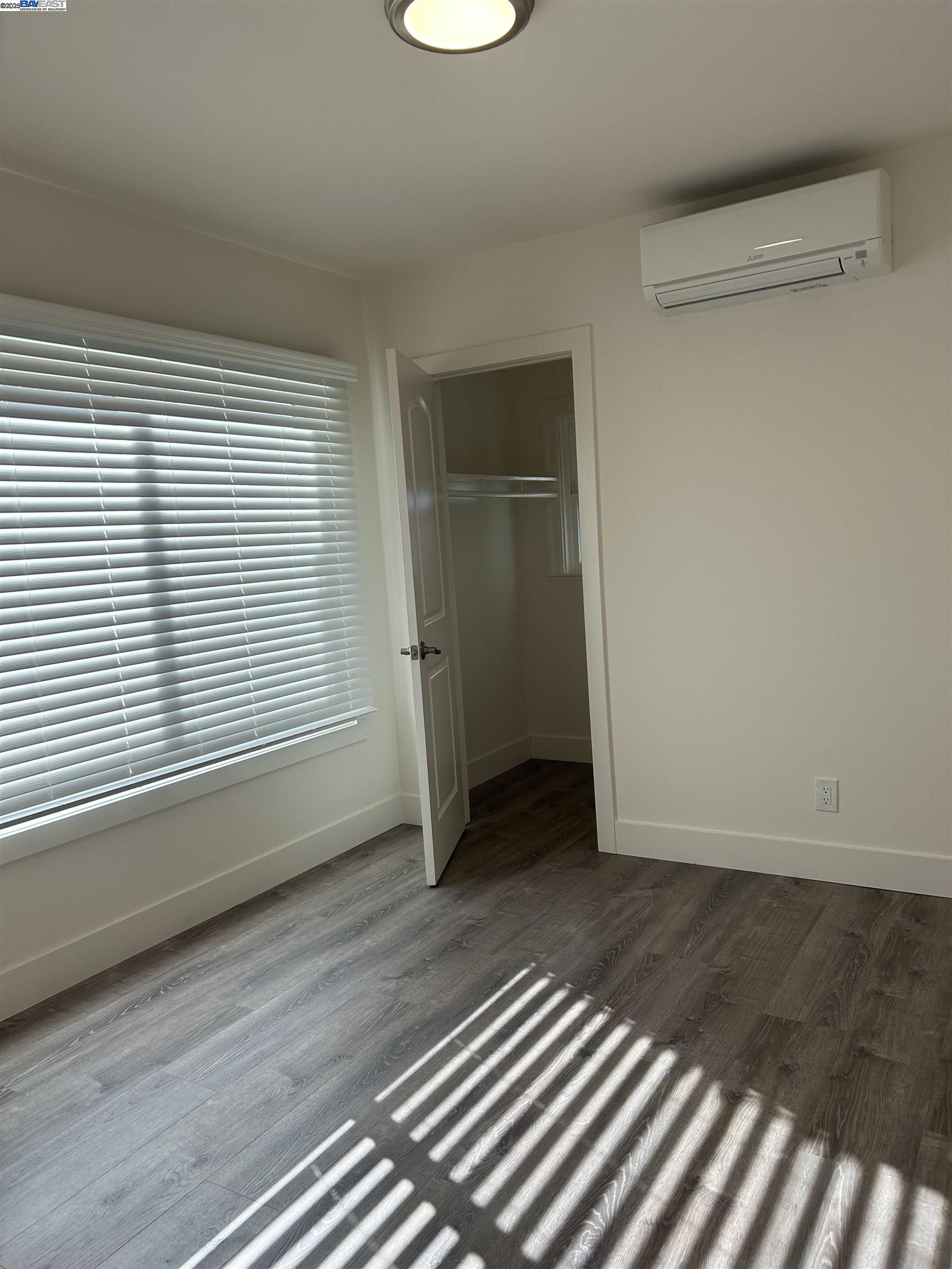 7808 Weld Street Oakland, CA 94621 - Photo 6 of 8 an empty room with wooden floor and windows