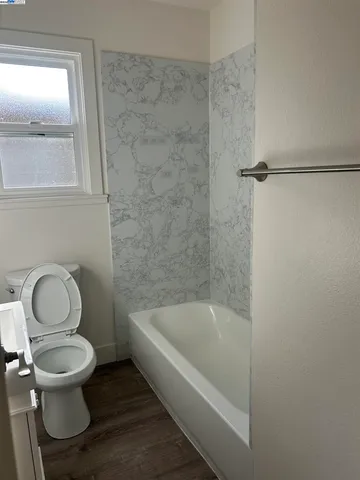 a white toilet sitting next to a bath tub