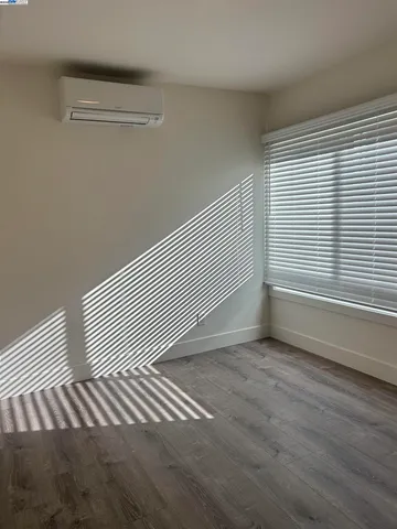 a view of a room with wooden floor and a window