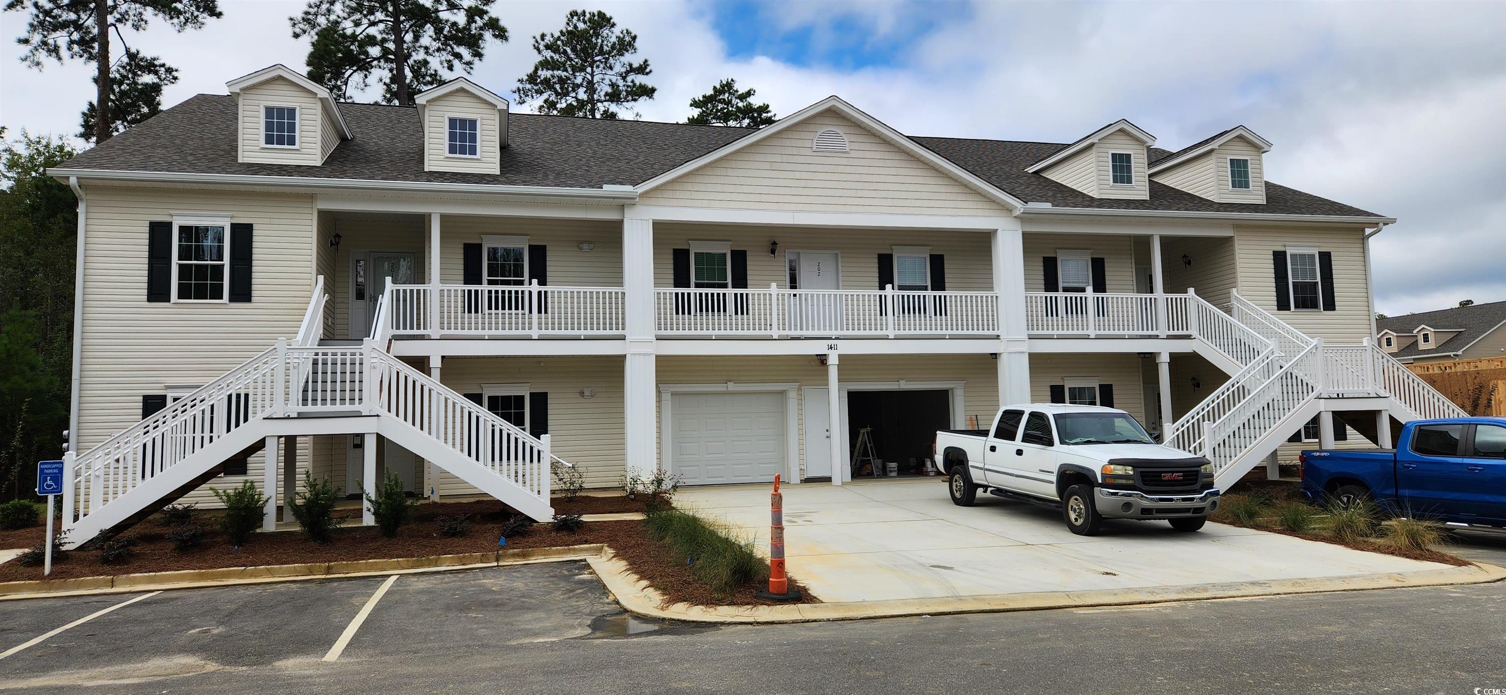 1411 Gooseneck Place, Unit 202 MIDDLE Murrells Inlet, SC 29576 - Photo 1 of 39 View of building exterior with stairs, an attached garage, and driveway
