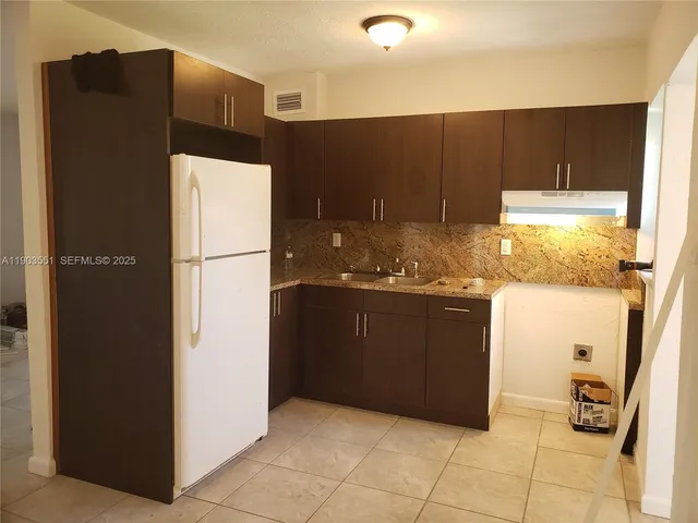 a kitchen with a refrigerator and a stove