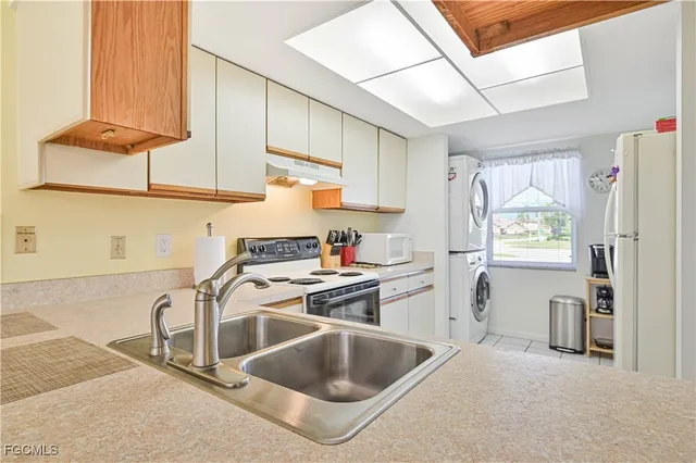 a kitchen with granite countertop a sink stainless steel appliances and cabinets