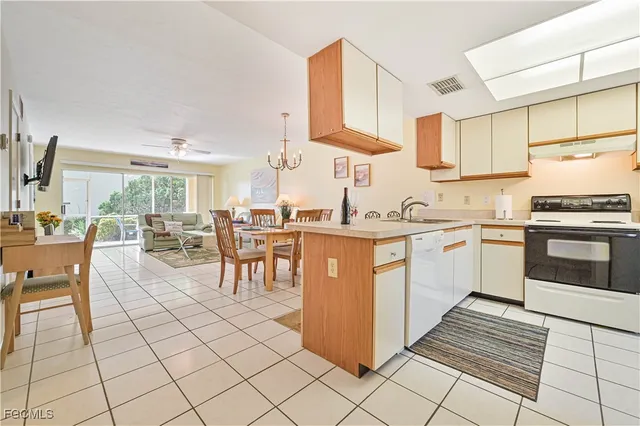 a kitchen with cabinets and chairs