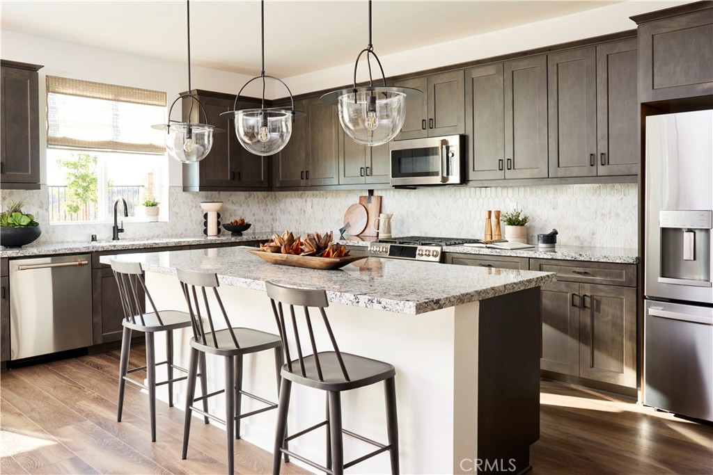11531 Jack Street Beaumont, CA 92223 - Photo 4 of 16 a kitchen with stainless steel appliances granite countertop a sink a stove a refrigerator cabinets and chairs