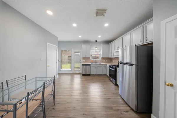 a kitchen with stainless steel appliances a refrigerator and a stove top oven