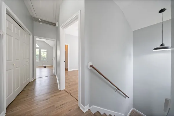 a view of a hallway with wooden floor and staircase