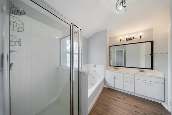 a hall with wooden floor and cabinets