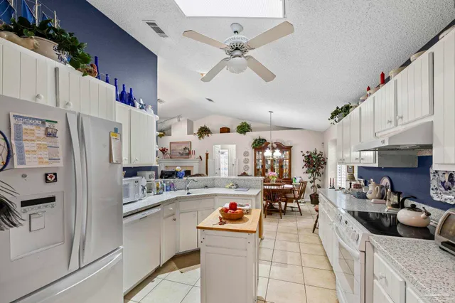 a kitchen with stainless steel appliances a sink a stove and white cabinets