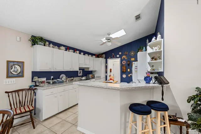 a kitchen with stainless steel appliances kitchen island granite countertop a refrigerator and a stove
