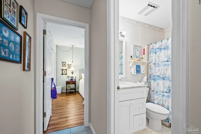 a bathroom with a granite countertop sink a toilet and shower curtain