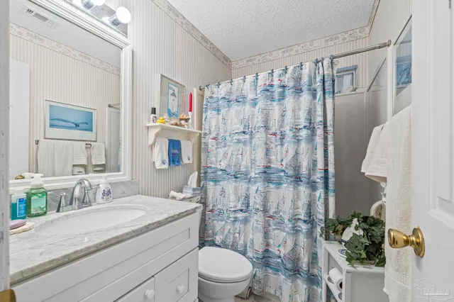 a bathroom with a sink mirror and toilet