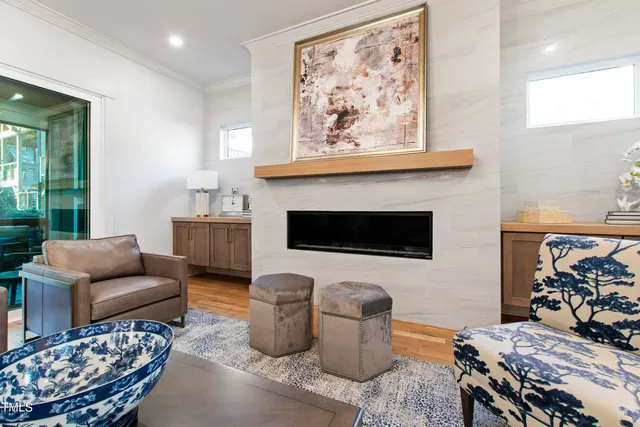 a living room with furniture a fireplace and a chandelier