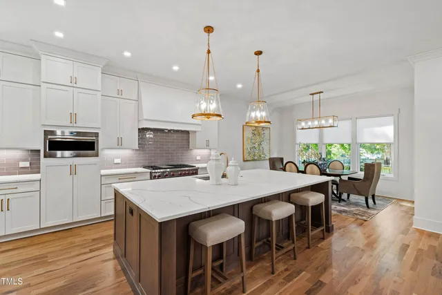 a kitchen with a stove a refrigerator a oven and a fireplace with wooden floor