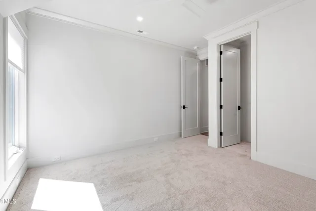 a spacious bedroom with a bed and large windows