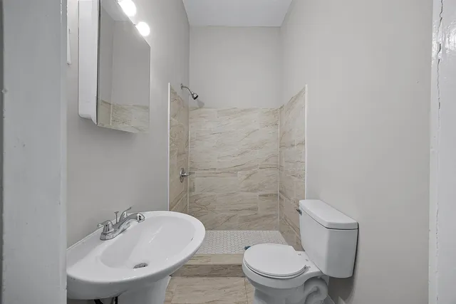 a bathroom with a sink a toilet and a mirror