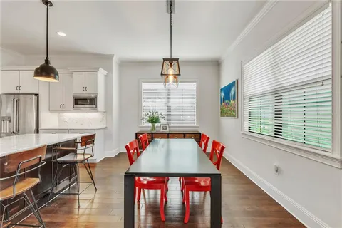 a kitchen with a stove a chandelier and a flat screen tv