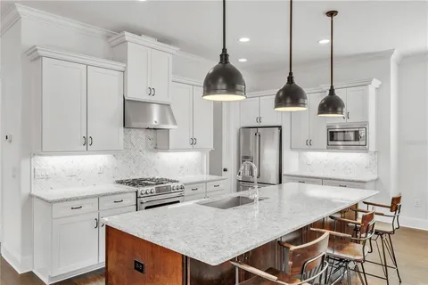 a kitchen with a sink a stove and chairs