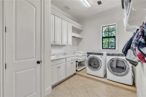 a utility room with sink dryer and washer