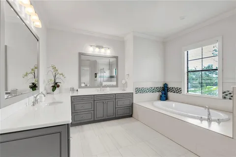 a spacious bathroom with a tub double sink and mirror