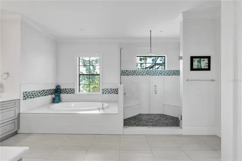 a bathroom with a tub a window and a shower