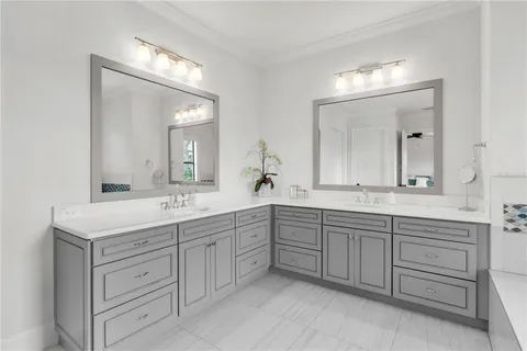 a spacious bathroom with double vanity and a mirror