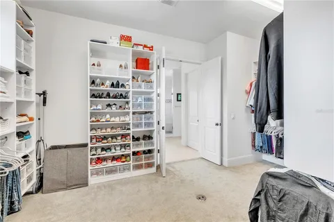 a view of walk in closet with clothes and shoes