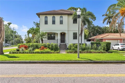 a white house with a yard and plants