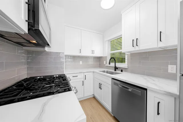 a kitchen with a sink a stove and cabinets