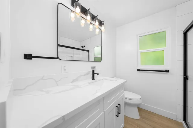 a bathroom with a sink mirror and toilet