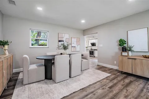 a living room with furniture a dining table and wooden floor