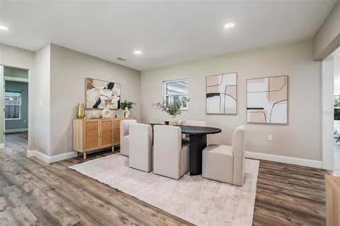 a kitchen with stainless steel appliances kitchen island granite countertop a stove a sink and white cabinets with wooden floor