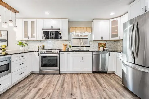 a kitchen with a stove a sink and a refrigerator