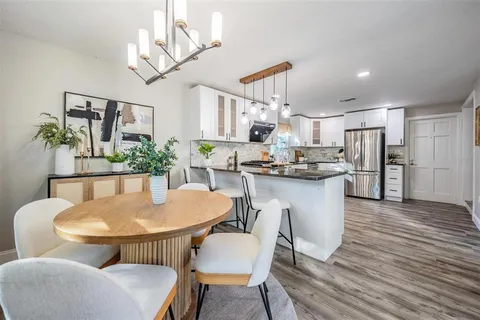a dining room with furniture potted plants and wooden floor