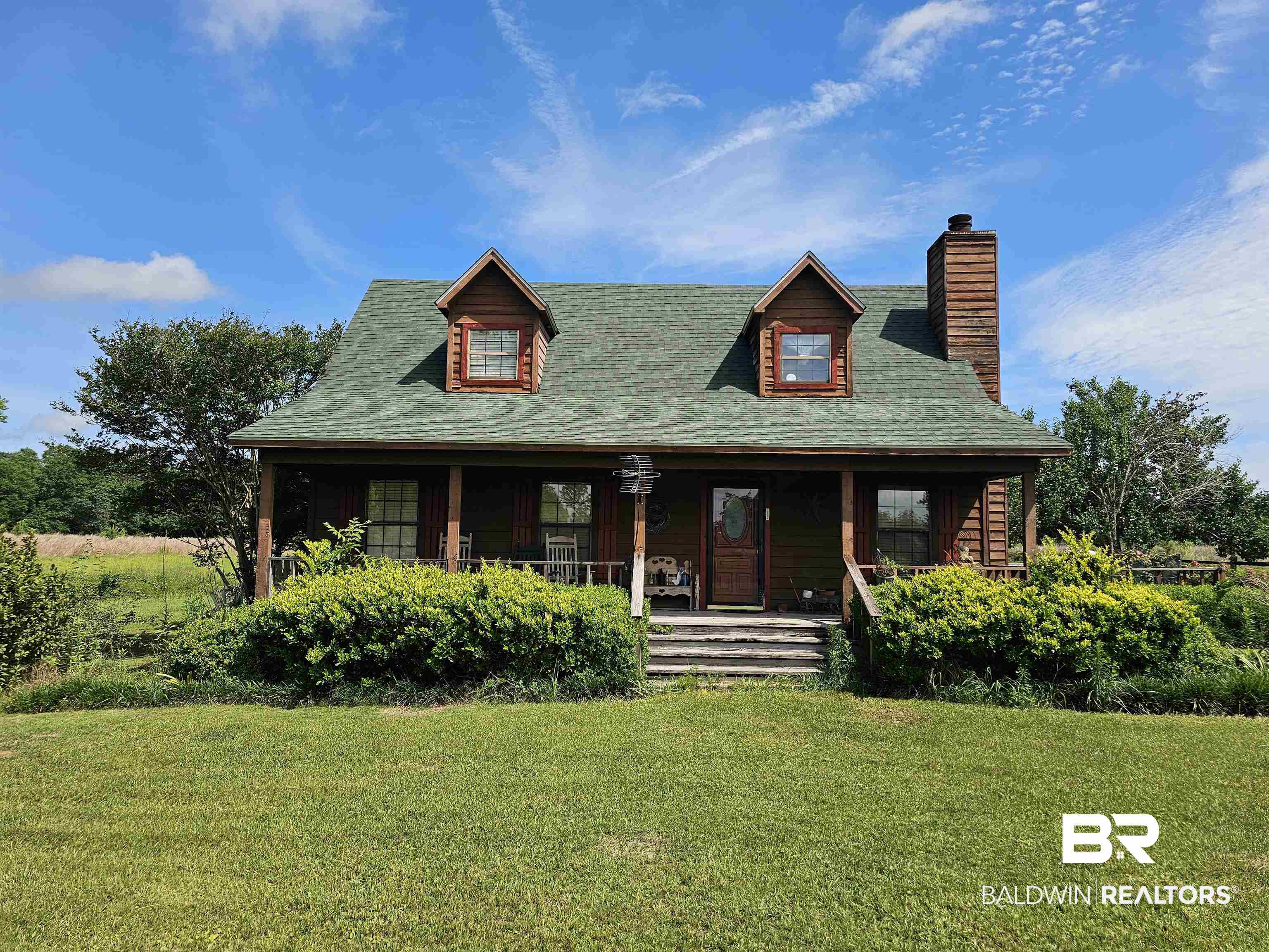 1818 Old Fannie Road Flomaton, AL 36441 - Photo 1 of 20 View of front of house featuring a front yard, covered porch, a chimney, and roof with shingles