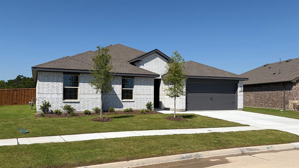 1913 Reveille Way Terrell, TX 75160 - Photo 27 of 35 Single-story residence featuring light-colored brick veneer, a dark asphalt shingle roof, and a two-car garage with a dark gray door