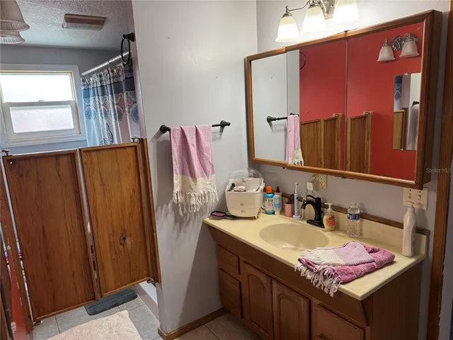 a bathroom with a sink a mirror and a shower