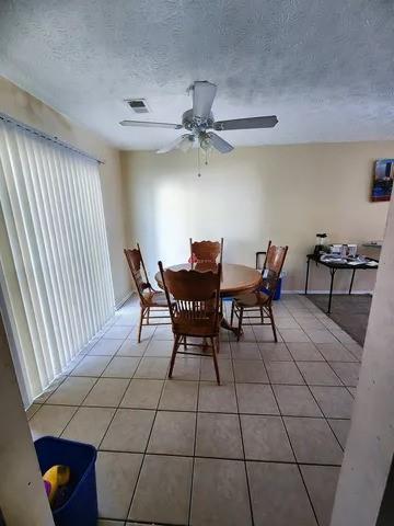 606 Pine Tree Trail, Unit 7C Atlanta, GA 30349 - Photo 4 of 8 a dining room with furniture and a chandelier fan