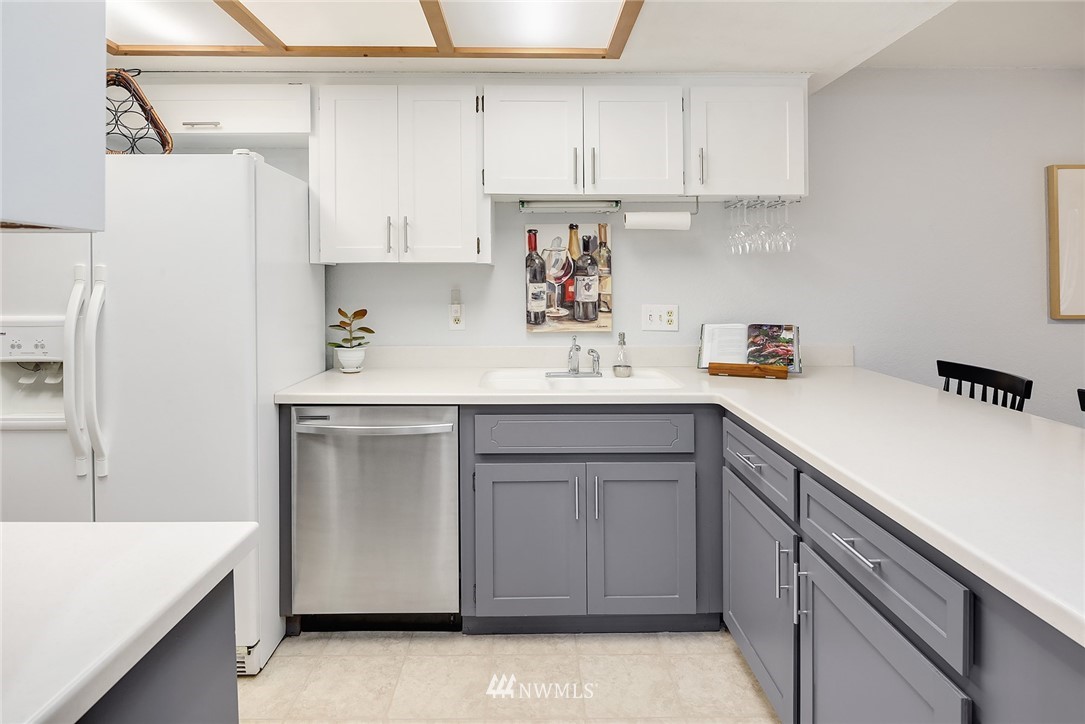 7512 218th Street Southwest, Unit 5 Edmonds, WA 98026 - Photo 4 of 25 a kitchen with a sink dishwasher and cabinets with wooden floor