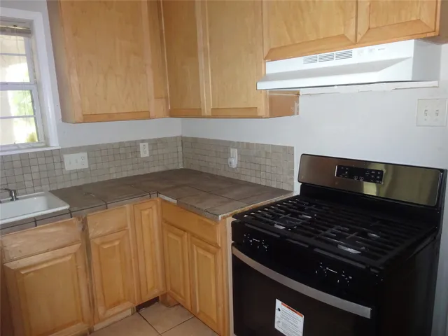 a stove top oven sitting inside of a kitchen