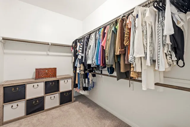 a view of walk in closet with clothes and shoes