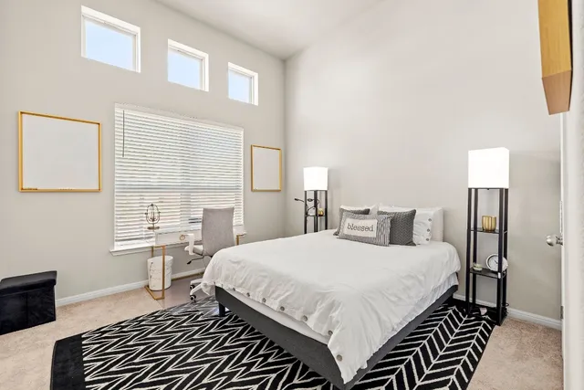 a bedroom with a bed and a dresser with wooden floor
