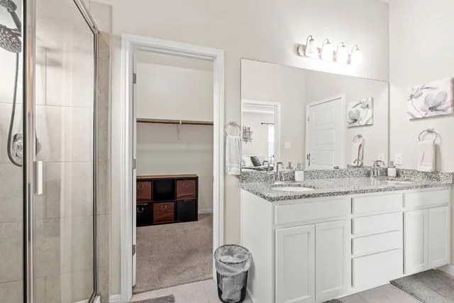 a en suite bathroom with a granite countertop sink and a mirror